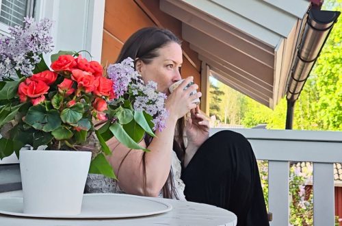 nainen aamukahvilla parvekkeella